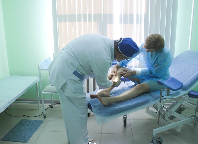 A surgeon examines a patient's veins before performing an operation.